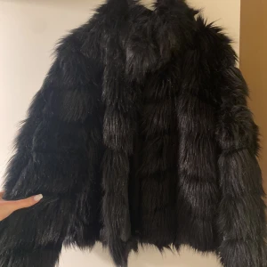 Pälsjacka Nelly  - Superfin svart pälsjacka från Nelly. Köpt här på Plick men aldrig använd då den tyvärr är för stor för mig. Jättefint skick, endast använd två ggr av förra ägaren. Varm och mysig, passar perfekt för både vår, höst och festkvällar på vintern. Strl 38 🥰