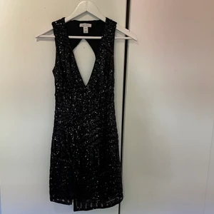 Glittrig klänning med slits och öppen rygg  - Använd vid ett tillfälle, från Nelly 