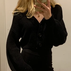Svart stickad croppad kofta - Superskön kort kofta från hm med tre större knappar. Funkar även som en söt, vanlig stickad topp. Säljer då den aldrig kommer till använding. Nypris: 150kr
