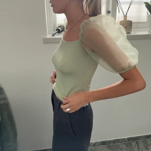 Puffärmar topp  - Puffärmad topp från Ginatricot. Knappt använd. Snyg grön färg. Jag ör storlek S men toppen funkar även den som bär M. 