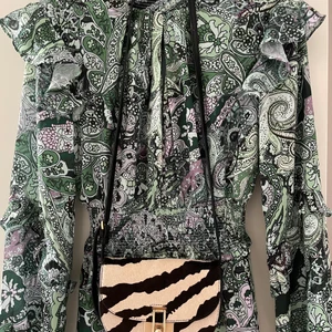 Supersnygg zebra-mönstrad skinnväska  - Säljer min grymt snygga axelremsväska, inköpt i London hösten 2021.  Använt väskan 3-4 ggr så den är i mycket bra skick!  Fraktas med spårbart, alternativt möts upp i Stockholm innanför tullarna. 🦓 💜  Nypris: 1200 kr