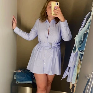 Skjortklänning, använd en gång! - Jättefin skjortklänning som enbart använts en gång på ett dop. Den är något längre i bak vilket är skönt då det faktiskt går att röra sig i klänningen utan att råka visa halva rumpan. Lös tråd i ena öglan för bältet, bild 3