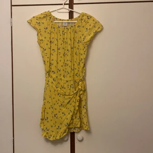 Lindex jumpsuit strl:146/152 - Den är använd en gång vid speciellt tillfälle. Är i nytt skick och i gul färg med blommor på. Säljer för att den ej passar längre.