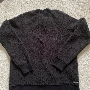 Calvin Klein tröja i fint skick! - Svart mysig tröja från Calvin Klein, använd ett fåtal gånger så i bra skick!  Storlek xs dam