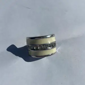 En vit ring med skimrande stenar, anpassningsbar storlek. 