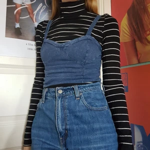 Blå croptop - Blått croppat linne i ett jeansimitationstyg. Väldigt mjuk och rörlig. Passar bra med en tröja under, eller bara som den är.