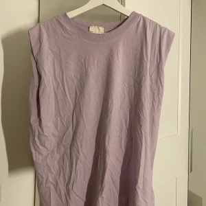 Lila t-shirt utan ärmar - Säljer denna lila t-shirten utan ärmar ifrån Gina Tricot