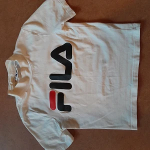 Fila t-shirt - En vit t-shirt från Fila med stort tryck på bröstet och litet i nacken. Croppad, tight, och supersnygg. Jättefint skick. Storlek XS. 75 kr plus ev frakt ☆