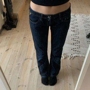 Lågmidjade Replay-jeans - Jättesnygga Lågmidjade replay-jeans köpta på second hand. De sitter bra på mig som är 165cm lång. De är uppsprättade längs ner vilket ger extra två cm. Innerbenslängd: 74cm Midjemått tvärs över: 35cm. Frakt 60kr men kan också mötas upp