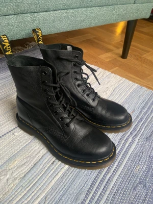 Doc Martens 1460 Pascal stl 40 - Använda ett fåtal gånger, mycket fint skick. Åtta hål. Jag säljer dem eftersom de blev för små. Regelbundet insmorda. Originalskosnören ingår. Nypris 2100 Köparen står för frakten.