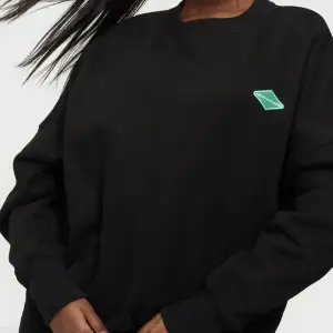 Nicki studio sweatshirt med grön logga framtil.  Modellen bär storlek small.  Slutsåld på hemsidan, priset på hemsidan 1099kr.