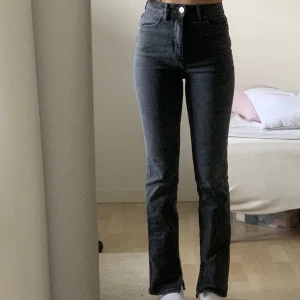 Svarta jeans med slits - Säljer dessa assnygga jeans i en svart wash som drar lite mer åt det gråa hållet. De är lite utsvängda & har slitsar där nere på båda benen & blir väldigt snyggt när man har sneakers. Säljer då de har blivit lite för tighta på mig. Inga slitningar🫶🏽