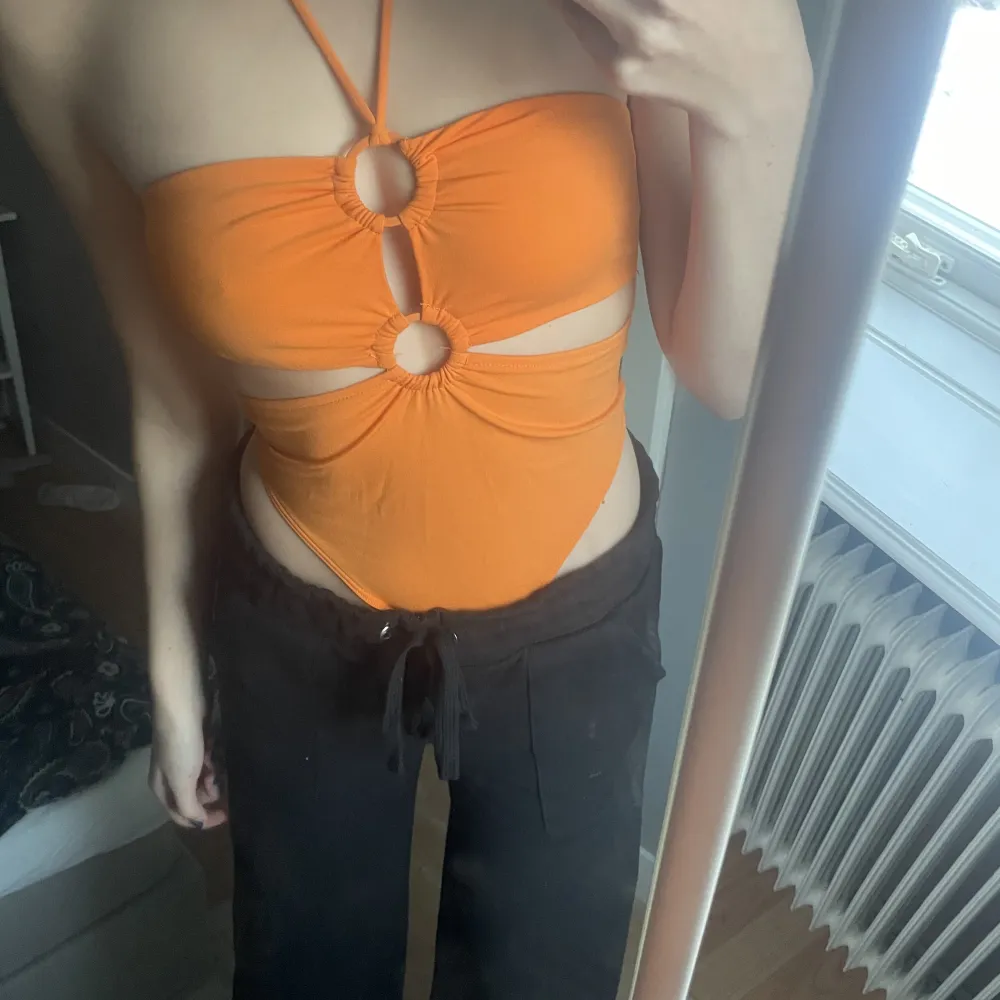 Helt oanvänd orange body från Zara. Med snöre runt halsen och fina detaljer vid bröstkorgen . Toppar.