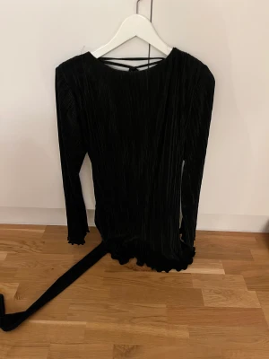 Plisserad klänning - Jättefin klänning, använd 1 gång. Öppen i ryggen och med bälte runt midjan. 