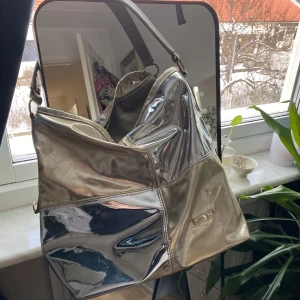 Cool väska  - Cool guld/silvrig väska!! Köppt secondhand. I fint skick med många olika fack i väskan. Passar en dator. 💕