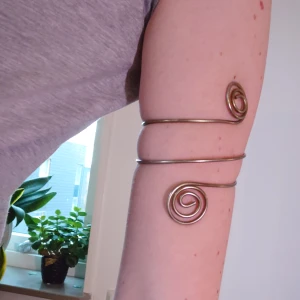 Armband för överarm - Häftigt och unikt över-arm-band som är böjbart och kan formas efter din kropp! Snirklar sig lätt och fint på överarmen. I bra skick. Mått just nu i denna form 7-8 cm i innermått för plats för arm. 