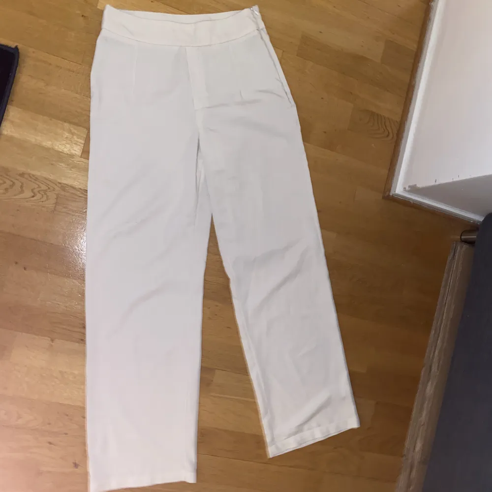 Vita kostymbyxor från Bikbok. Ganska genomskinliga, så man får ha hudfärgade trosor under så syns inget. . Jeans & Byxor.