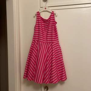 Superfin klänning för barn, använd bara ett fåtal gånger. Nyskick med hög kvalitetskänsla (integrerad underkjol).  Märkt stl 10 (år), vilket motsvarar 137-140 cl. En toppenklänning!  https://www.babyshop.se/content/view/Storleksguide-Ralph-Lauren