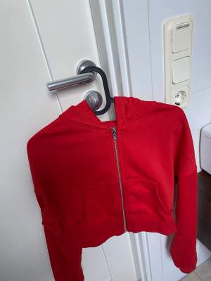 Säljer denna röda croppade zip up hoodie från H&M. Plagget är i bra skick då det bara har används få gånger. Priset kan diskuteras, betalas med Swish. Kan skickas men köpare står för frakten 