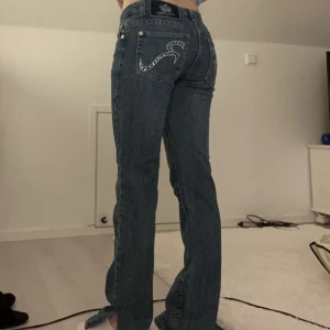 Lågmidjade jeans - Vintage lågmidjade jeans i stl 34, liten slits nere vid benen och superfina! 