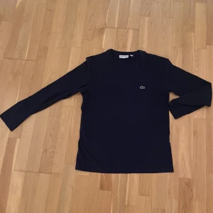 Lacoste långärmad tröja   - Denna tröja är i bra skick. Den passar mig perfekt som är 172cm. Sitter lagom löst. Köpte denna i Köpenhamns flygplats, och samma modell säljs nu för 649kr på Zalando. 