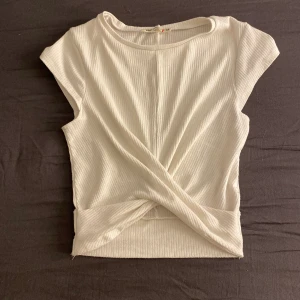 vit tröja - ribbad tröja m en liten korsning längst ner på magen! okej skick.