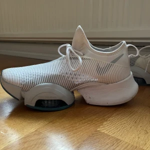 Nike sneakers  - Ett par näst intill oanvända vita löpskor från Nike. Väldigt studsiga och sköna. Använda tre gånger, där av en lite smutsig sula. Säljes på grund av fel storlek!