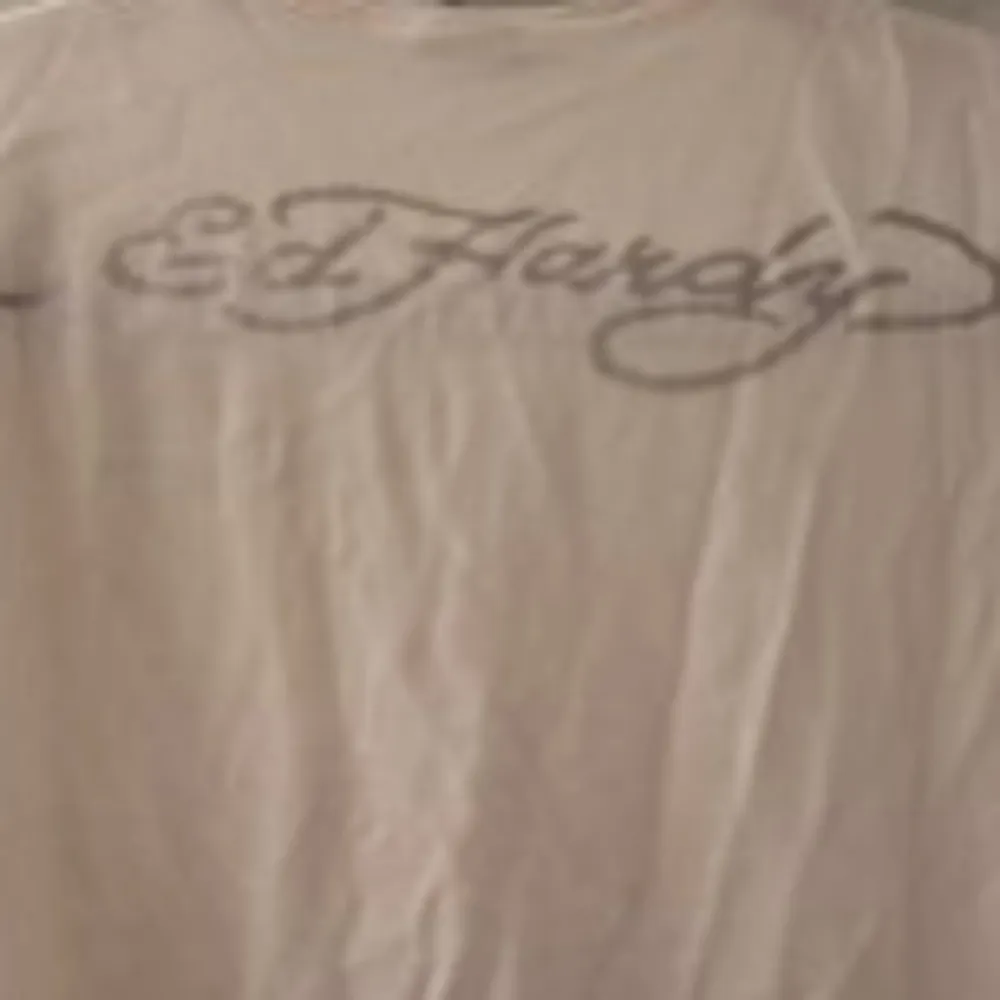 Säljer en T-shirt med märket Ed Hardy. Denna är vit med mönster i svart och silver. Skön och töjbar, fin passform.. T-shirts.