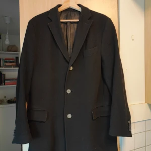 Rock - Rock från Oscar Jacobsson med 3 knappar. Storlek L-XL (tror jag, det står ej i plagget) Tyget på insidan av ena ärmen är slitet. Det syns inte alls dock.