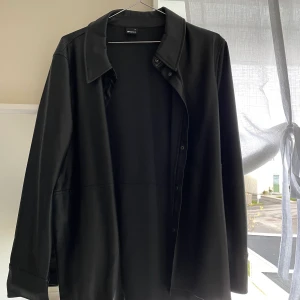 Svart läder skjorta - Säljer en perfekt oversized läder skjorta från Gina Tricot i storlek 44. Använd en gång så det är ett mycket bra skick. 