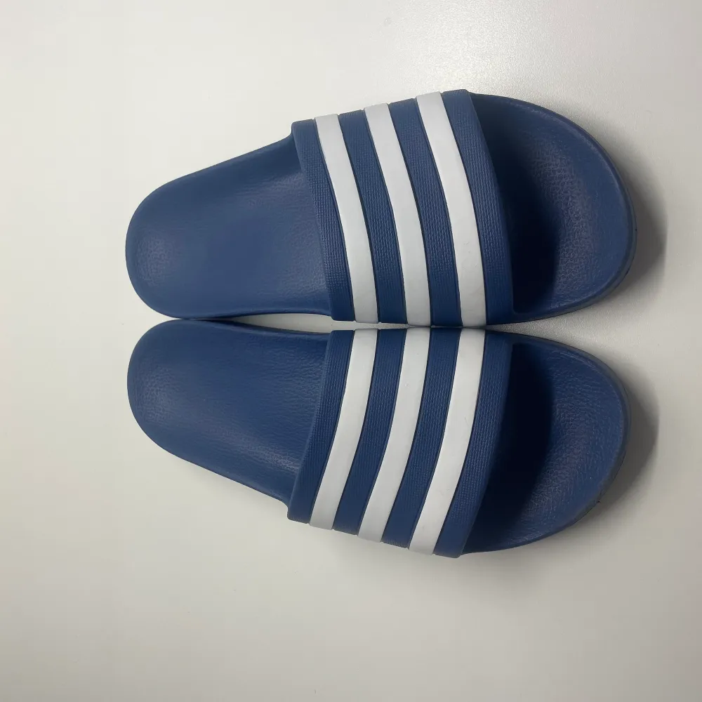 Hej 👋 säljer ett par blåa adidas tofflor i storlek 42😁 nästan aldrig använda🎉väldigt bekväma‼️säljer för har växt ur dem‼️. Skor.