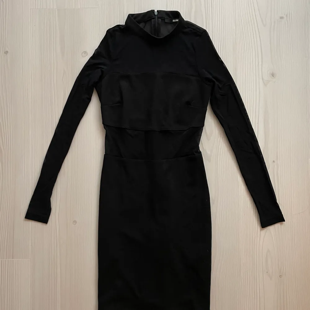 Här har vi en fortfarande läcker favorit som behöver ny ägare! En svart klänning med mesh detaljer och blixtlås i ryggen, så den är enkel att få på! Sitter kroppsnära och slutar ovanför knäna. (Jag är 166cm). Klänningar.