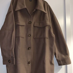 Oanvänd tunn kappa  - Oanvänd brun oversized tunn kappa. 