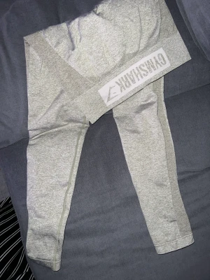 Gymshark tights  - Säljer ett par grå beigea tights från gymshark i storlek M, passar även en S. Använda ca 3 gånger. Sitter snyggt på & håller sig uppe! 