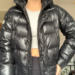 MONCLER Puffer Jacket  - Avtagbar päls.  Skick: Använd men i gott skick.  Något sliten vid muddarna längst ner på ärmen.   Moncler strl 2 - MEDIUM Aningen liten i storleken  Material:  Outer: Polyamide 100% Lining: Polyamide 100%, Feather Down 100%, Modacrylic 93%, Polyester 7%