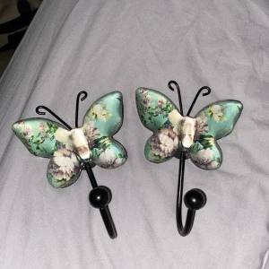 Fjärils hängare  - Väldigt fina Hängare ”krokar” i fjärils form med blommor, ej använda. Handgjorda vad jag minns och pris kan diskuteras. 