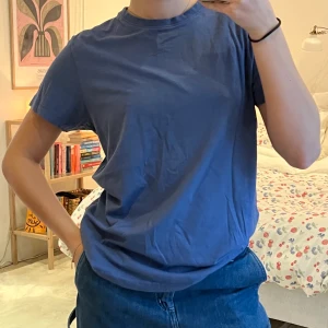 T-shirt blå - Simpel t-shirt från Dressman. Mörk, dusty blå färg. Jättebra skick! Stl M men sitter inte för oversized på mig som brukar ha S.