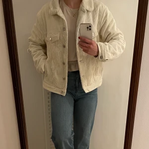 Manchesterjacka - Vit gosig manchesterjacka i naturmaterial. Cool modell som håller värmen i mellanperioderna. Storleken är medium och jag har vanligtvis small, men tyckte bättre om denna passformen. 