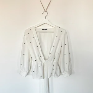 Festlig blus - En jättefin festlig blus från SHEIN, endast använd en gång. Har ”pärl” detaljer på tröjan. Kan knytas på framsidan, jättefint till kostymbyxor med bralette/bandeau under för en utekväll.