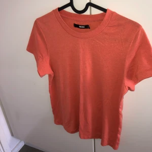 Orange T-shirt  - Säljer min oranga T-shirt frpn bikbok då jag inte använder den längre, jätte söt och fin, en kortare modell av T-shirt, storlek xs