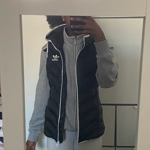 Adidas väst - Fick den här i födelsedagspresent förra året men har knappt användt den, den är helt enkelt som ny. Den kommer även me luva och två fickor som har dragkedja. Västen är inte så tunn som man tror så man kan ha den både på hösten. vår och sommar. När man stänger den sitter den åt bra vid midja o.s.v man såg det inte så tydligt på bilden eftersom jag hade en tjock kofta under. PRIS KAN DISKUTERAS