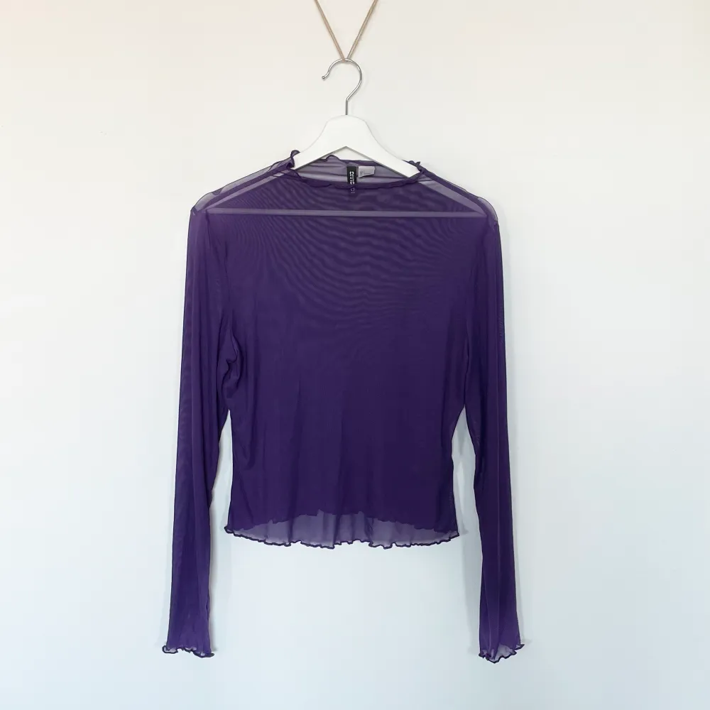 Mesh genomskinlig lila tröja från H&M, den har fina virvlar på kanterna på tröjan, ärmen och halsen.   Endast använd en gång därmed nyskick.. Toppar.