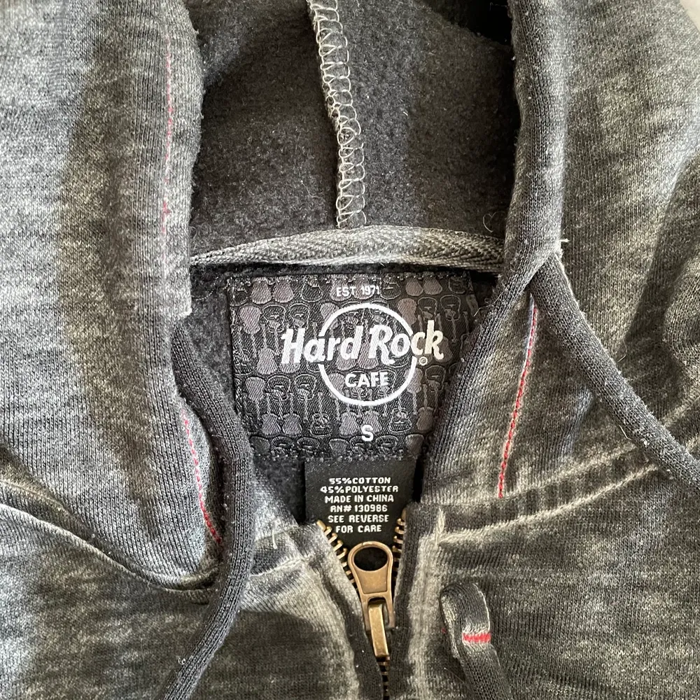 En stentvättade Hard rock café zip hoodie med röd text. Tröjan är i gott skick och är otroligt mjuk i matrialet. Jag bär vanligtvis S och är 170 cm lång.. Tröjor & Koftor.