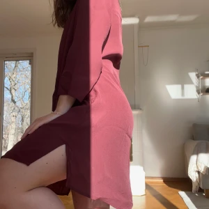 Vinröd klänning - Gullig klänning i vinrött/lila som strax ovanför knäna på mig som är 160 cm lång!! Superfin med ett skärp i midjan😍 