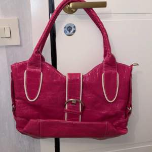 Rosa handväska i väldigt gott skick. Har aldrig använts utan bara legat i garderoben. Ganska stor och rymlig. Cirka 36cm längden, 30cm höjden (räknar inte med handtagen).