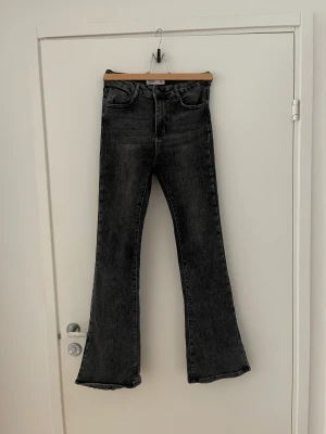 Gråa jeans med slit - bootcut jeans med slit från prettylittlething. storlek 36. Använda en gång
