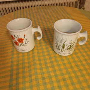 Två månadskoppar Oktober och Maj månad . - Två Fina samlar muggar Oktober och Maj månad porslin med blommotiv 10 cm stora ..Inget slitage finnes och hämtas i Skene alt skickas .