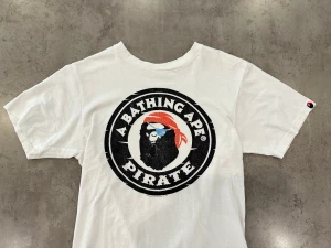Bape Pirate Tee *2009* - A Bathing Ape / Bape Pirate Tee Från 2009, Skick enligt bilder Men det är förväntat med tanke på att det är en Vintage (2009) och därav det billiga priset. Size S (Small) 