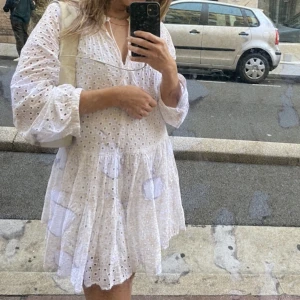 Vit klänning Asos 36 - Vit fin sommarklänning med ”broderat” mönster, knappar i ärmslut och snören som går att knyta i rosett i halsringningen.     Obs fläckarna på första bilden är från spegeln som bilden togs i, inte från klänningen!