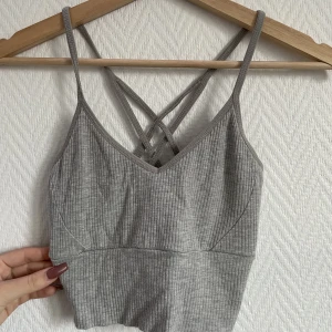 Grå topp - Jätte skön grå topp, super stretchig men fina detaljer i ryggen  Skulle även passa som en S 